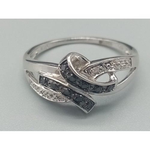 499 - A 9K White Gold Double-Crossover Diamond Ring in a Bow design - With Black and White Diamonds. Size ... 