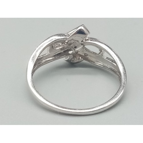 499 - A 9K White Gold Double-Crossover Diamond Ring in a Bow design - With Black and White Diamonds. Size ... 