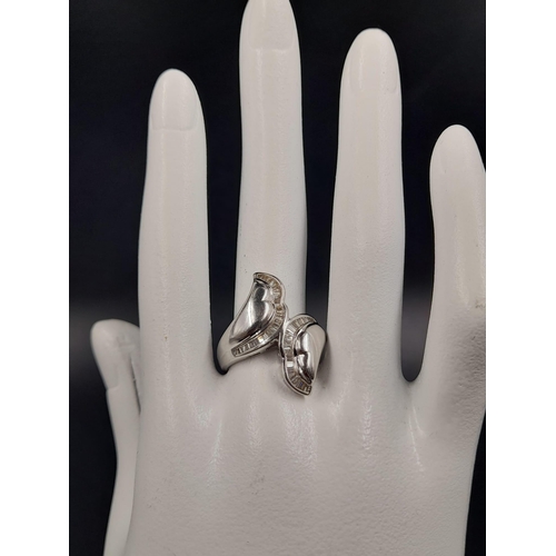 372 - A Modern 18K White Gold Twist Diamond Ring. Size M.
8.79g.