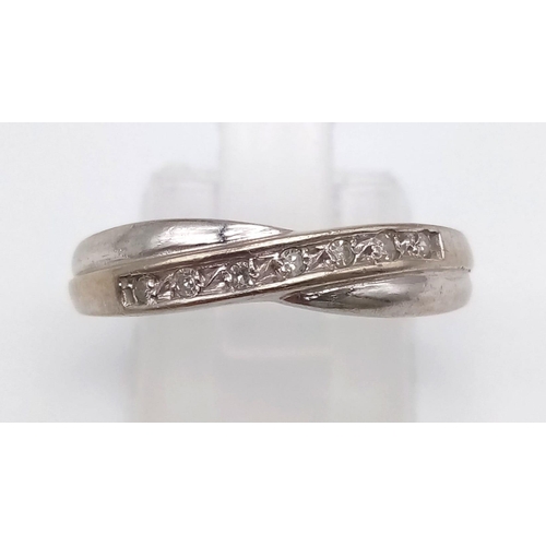 589 - An 18K White Gold Diamond Half-Eternity Twist Ring.
Size 0.   2.86g