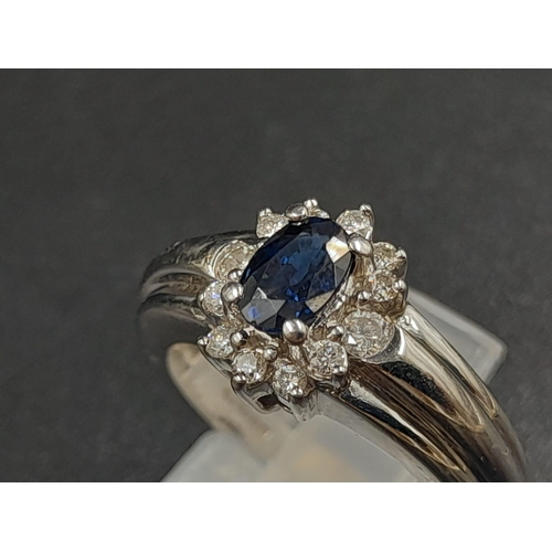 1238 - An 18K White Gold Diamond and Sapphire Ring. Centre stone sapphire surrounded by a halo of diamonds.... 