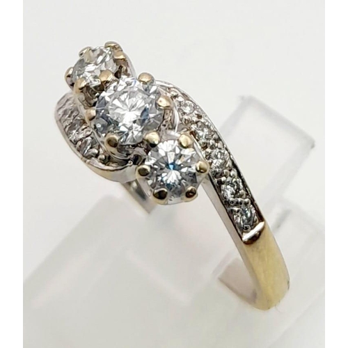 1160 - An 18K Yellow Gold Three-Stone Diamond Crossover Ring. Three central diamonds supported by waves of ... 