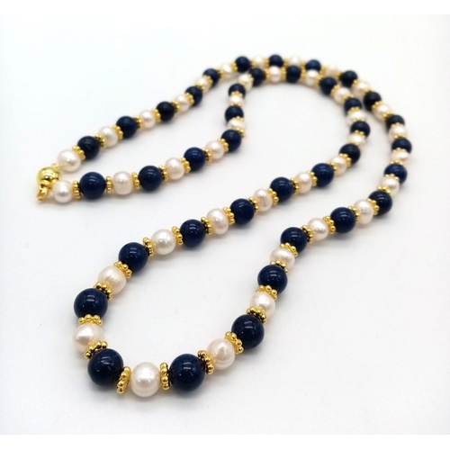 400 - A Freshwater Pearl and Lapis Lazuli Bead Necklace. 8mm beads. Gilded spacers and clasp. 66cm