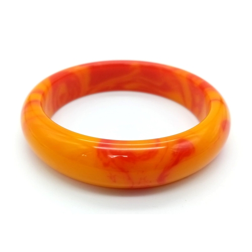 421 - A Red and Orange Swirl Jade Bangle. 6cm inner diameter. 16mm width.