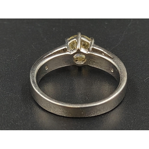 410 - A Platinum Diamond Ring - Central stone with small baguette-cut diamonds on shoulders. Size M. 7.86g