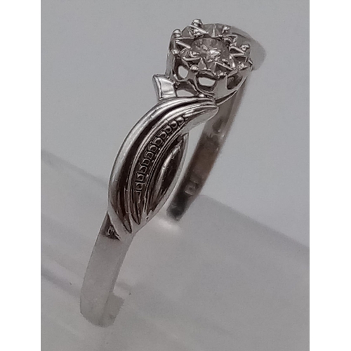 673 - A 9K White Gold Illusion setting Diamond Solitaire Ring with nice decoration on shoulder. Size T. 
T... 