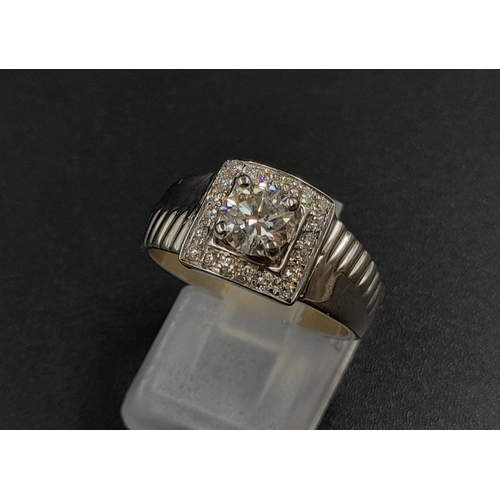 1370 - A 9K White Gold Belt-Buckle Diamond Ring. Central stone surrounded by a square belt-buckle of diamon... 