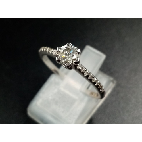 1405 - A 9K White Gold Diamond Ring. Central diamond with diamonds on shoulders. 0.35 and 0.20ct. Size O.
1... 