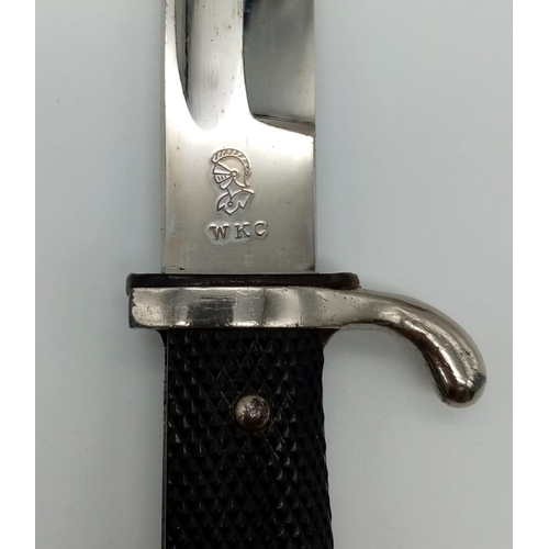 911 - A German Third Reich Dress Bayonet by WKC with Scabbard.
Makers mark on blade. Total length - 39cm