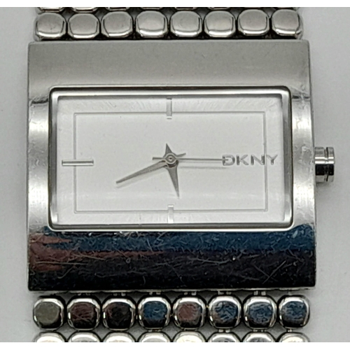 1190 - A LADIES DKNY WATCH ON A STAINLESS STEEL BRACELET  32 x 30mm