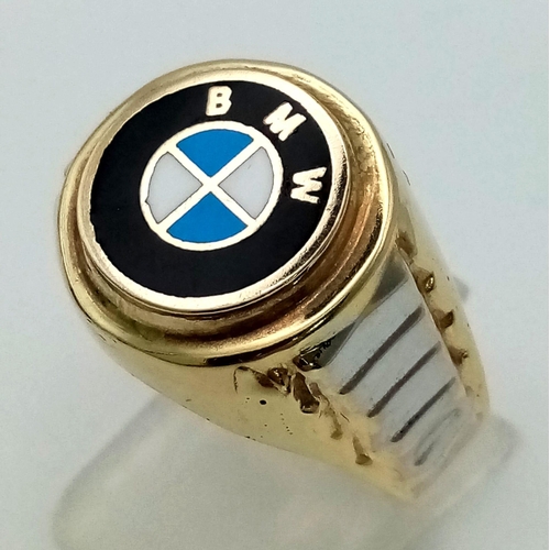 1054 - A 14K yellow gold ring with white gold highlights and the BMW logo on top. Ring size: Y, weight: 5.9... 