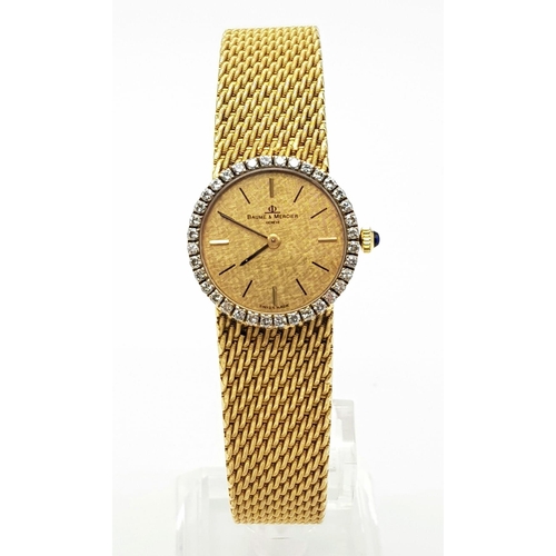 885 - A Baume and Mercier 18k Gold Ladies Watch. 18k Gold mesh strap and case - 25mm. Gold tone dial with ... 