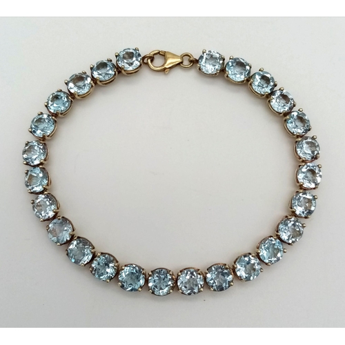 1268 - A Blue Topaz Tennis Bracelet set in 925 Gilded Silver. 19cm