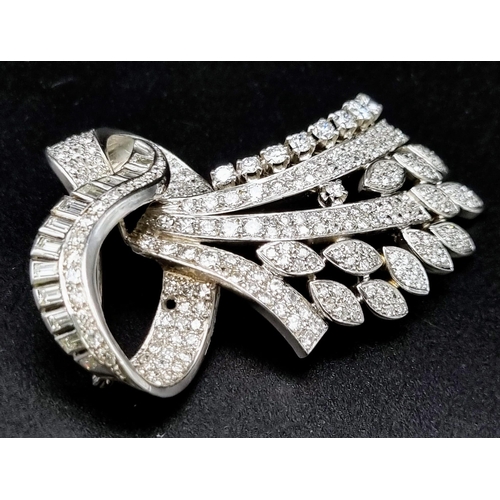 44 - A 6ct Diamond and Platinum Bow Brooch. Brilliant cut baguette, round cut and encrusted diamonds crea... 