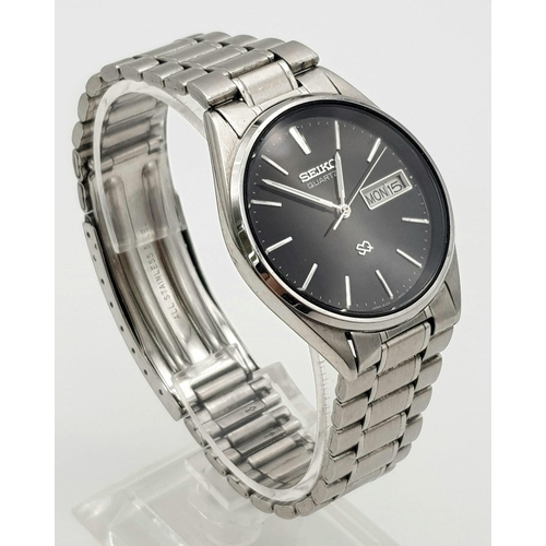 632 - A SEIKO QUARTZ WATCH IN STAINLESS STEEL WITH DAY/DATE BOX AND ATTRACTIVE BLACK DIAL.   34mm