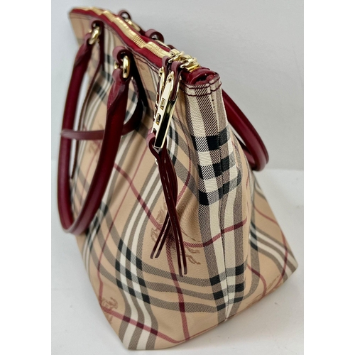 422 - A Classic Burberry Small Tote Bag with Dust Cover. Gilded hardware. Inner Red liner with zipped comp... 