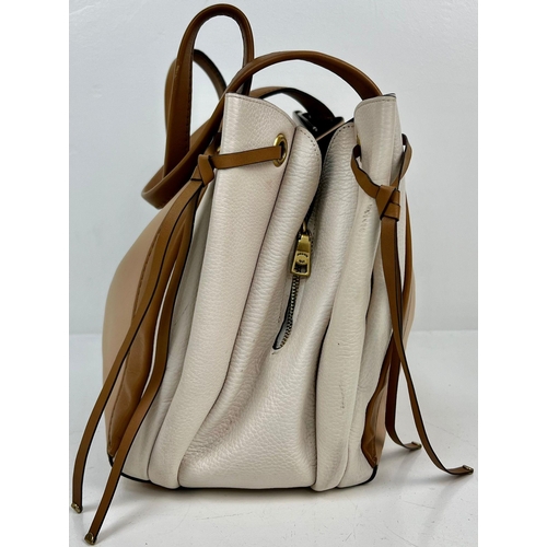 658 - A BEAUTIFUL BEIGE AND CREAM COACH HANDBAG IN SOFT LEATHER AND SUEDE LINED IN VERY GOOD CONDITION.