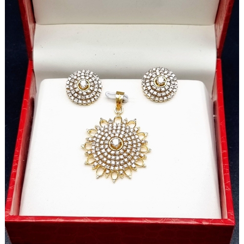 25 - A Diamond Brooch and Earring Set. 4ct of diamonds spread over a circular pendant and earrings. Set i... 