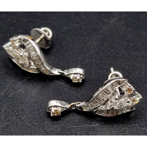 352 - A Pair of Platinum and Diamond Drop Earrings. Baguette, oval and round cut diamonds create a beautif... 