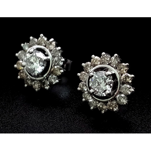 565 - A Pair of Platinum Diamond Floral Stud Earrings. Central diamond cabochon surrounded by a halo of di... 