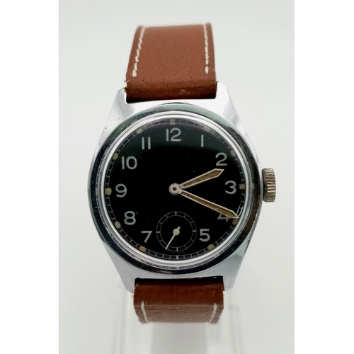 990 - A VINTAGE MILITARY STYLE WRIST WATCH WITH MANUAL MOVEMENT AND LEATHER STRAP.  32mm   FWO.