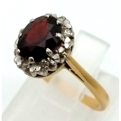 144 - An 18K Yellow Gold, Garnet and Diamond Ring. Central oval garnet with a diamond surround. Size L. 3.... 