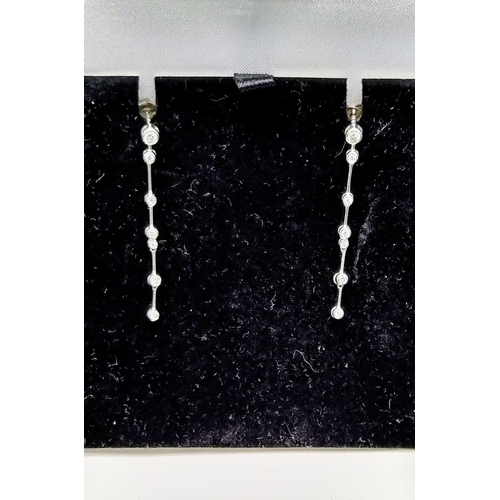 852 - A Pair of 18K White Gold Diamond Drop earrings. 4cm drop. 
1.2g total weight.