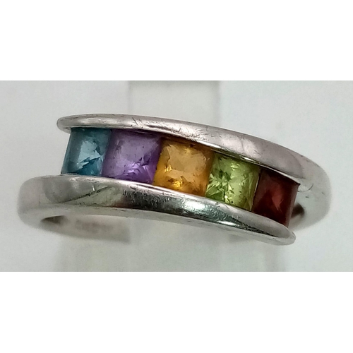 921 - A 9K white gold ring in a cross over design with five gemstones (aquamarine, amethyst, citrine, peri... 