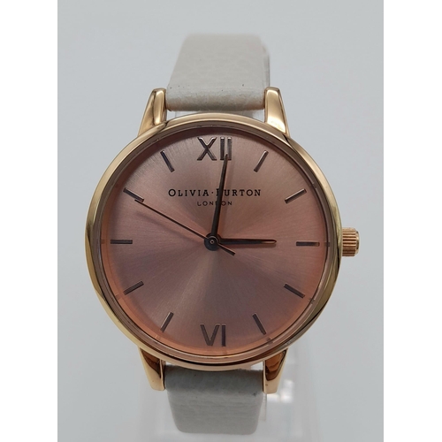 1119 - An Olivia Burton of London Ladies Quartz Watch. White leather strap. Rose gold coloured dial. Quartz... 