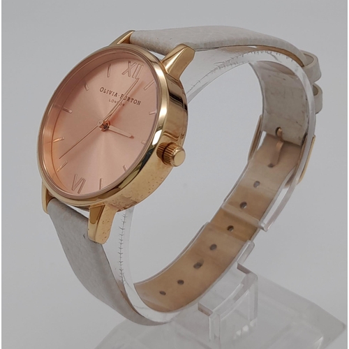 1119 - An Olivia Burton of London Ladies Quartz Watch. White leather strap. Rose gold coloured dial. Quartz... 