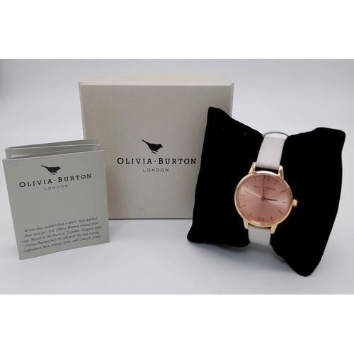 1119 - An Olivia Burton of London Ladies Quartz Watch. White leather strap. Rose gold coloured dial. Quartz... 