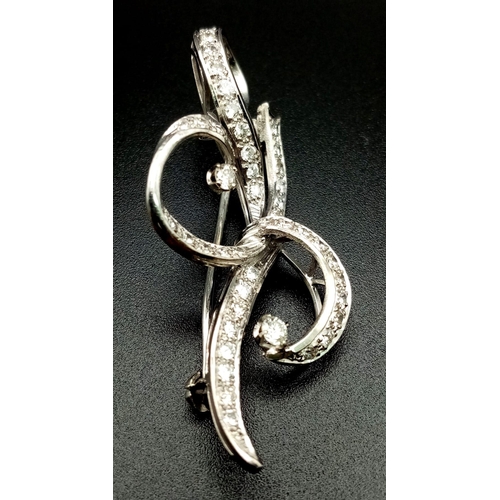 109 - A 1940s Platinum and Diamond Scrolled Brooch. 2ct of brilliant round cut diamonds make this piece hi... 