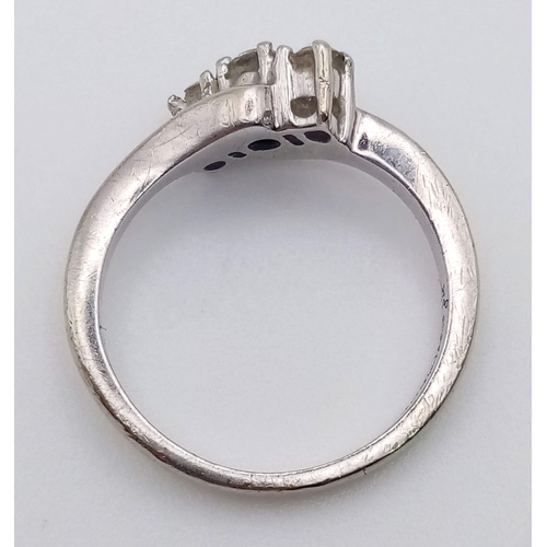 1186 - A 9K white gold ring with a diamond (0.25 c) trilogy on a twist design. Ring size: J, weight: 2.5 g