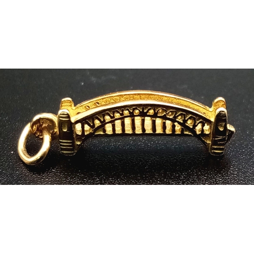 1239 - A 9K yellow gold, finely detailed, bridge charm. Length: 21 mm, weight: 1.3 g.