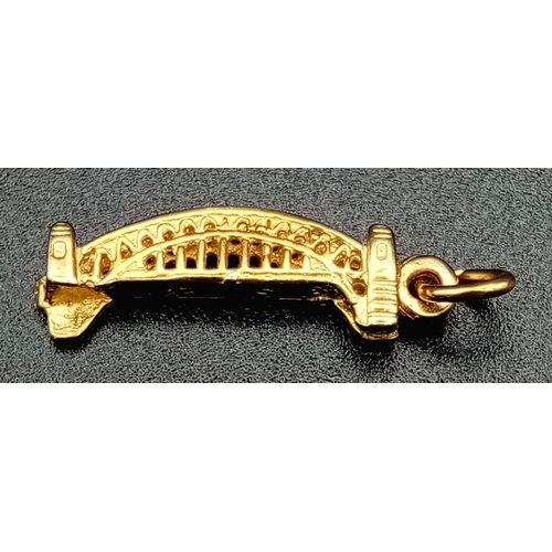 1239 - A 9K yellow gold, finely detailed, bridge charm. Length: 21 mm, weight: 1.3 g.