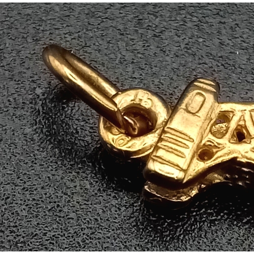 1239 - A 9K yellow gold, finely detailed, bridge charm. Length: 21 mm, weight: 1.3 g.