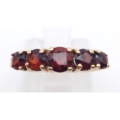 849 - A 9K Yellow Gold and Garnet Ring. Five bright garnets. Size N/O. 2g total weight.