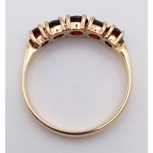 849 - A 9K Yellow Gold and Garnet Ring. Five bright garnets. Size N/O. 2g total weight.