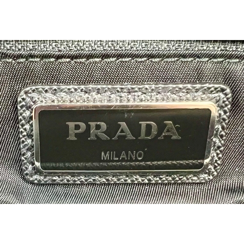 415 - A Small Prada Backpack. Two outer zipped compartments and one zipped inner compartment. Silver tone ... 