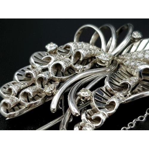 899 - A Platinum and Diamond Brooch. A beautiful coastal themed piece with diamond encrusted shells amongs... 