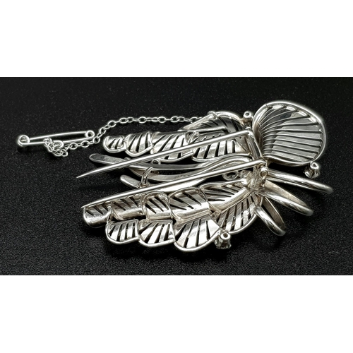 899 - A Platinum and Diamond Brooch. A beautiful coastal themed piece with diamond encrusted shells amongs... 