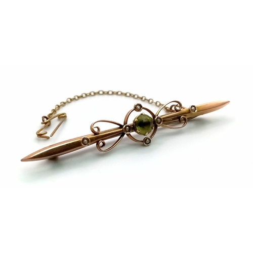 568 - An Antique 9K Yellow Gold Peridot and Seed Pearl Bar Brooch. With safety chain. 6.5cm length. 3.1g t... 