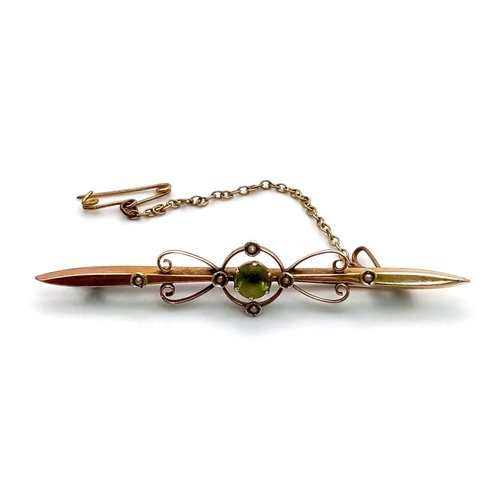 568 - An Antique 9K Yellow Gold Peridot and Seed Pearl Bar Brooch. With safety chain. 6.5cm length. 3.1g t... 