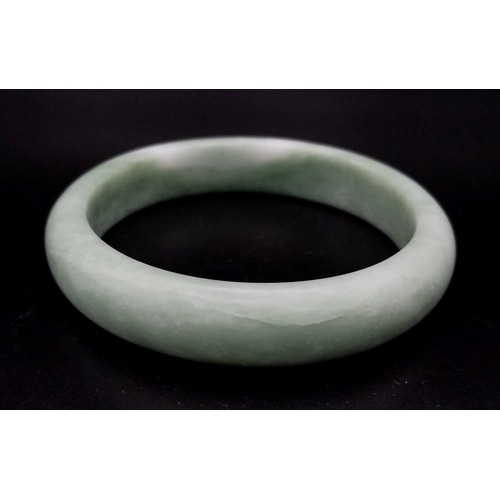 400 - A Pale Green Jade Bangle. 6cm inner diameter.