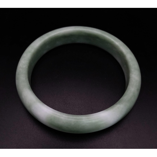 400 - A Pale Green Jade Bangle. 6cm inner diameter.