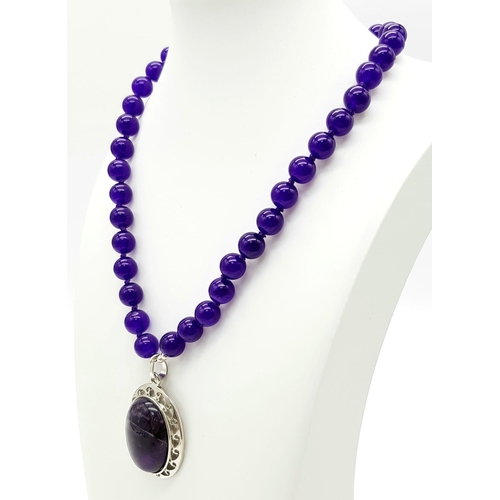 542 - An Amethyst Bead Necklace with Amethyst Oval Pendant. 22 and 5.5cm. Beads - 10mm.