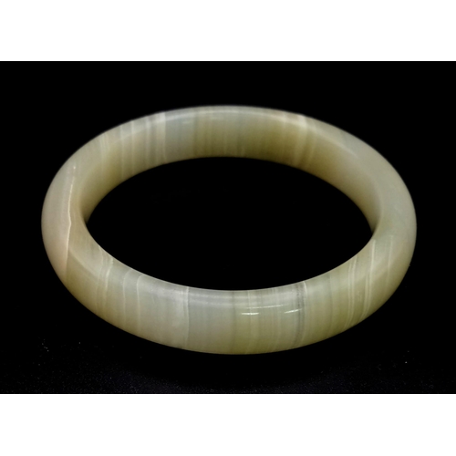 598 - A White and Green Jade Bangle. 6cm inner diameter.