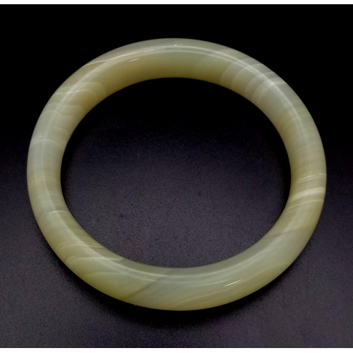 598 - A White and Green Jade Bangle. 6cm inner diameter.