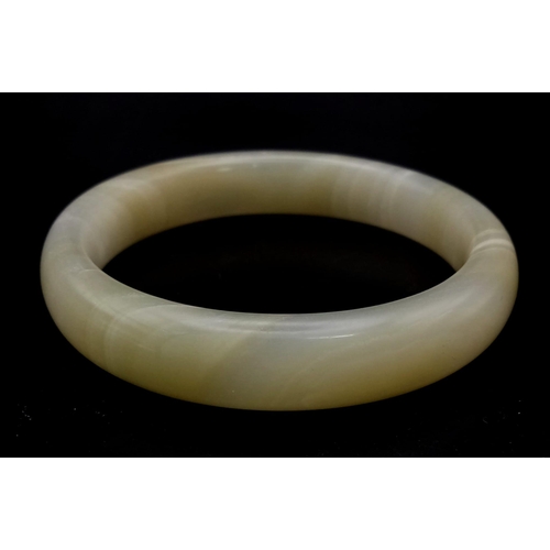 598 - A White and Green Jade Bangle. 6cm inner diameter.