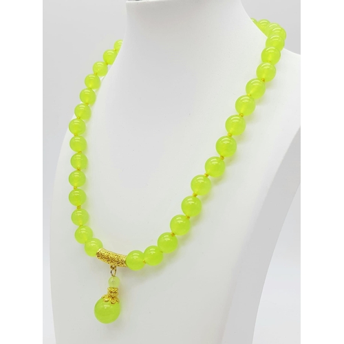 386 - A Peridot Bead Necklace with Drop Gilded Pendant and Clasp. 42cm and 3cm. Beads - 10mm